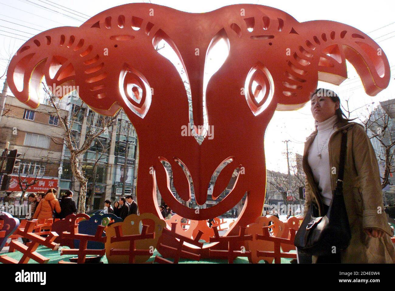 A Chinese shopper walks past a Lunar New Year decoration outside a shopping  mall in Shanghai January 15, 2003. Chinese around the globe will usher in  the Year of the Goat on