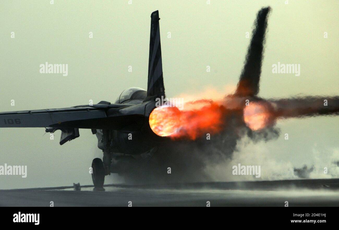 An F-14 Tomcat fighter jet spews flames from its afterburners as it is catapulted off the USS Kitty Hawk aircraft carrier in the northern Gulf March 30, 2003. The carriers airwing flew 104 total sorties over Iraq yesterday and dropped bombs on targets including air defence sites, a train loaded with tanks and a surface-to-air missile site. REUTERS/Paul Hanna  PH/VB Stock Photo