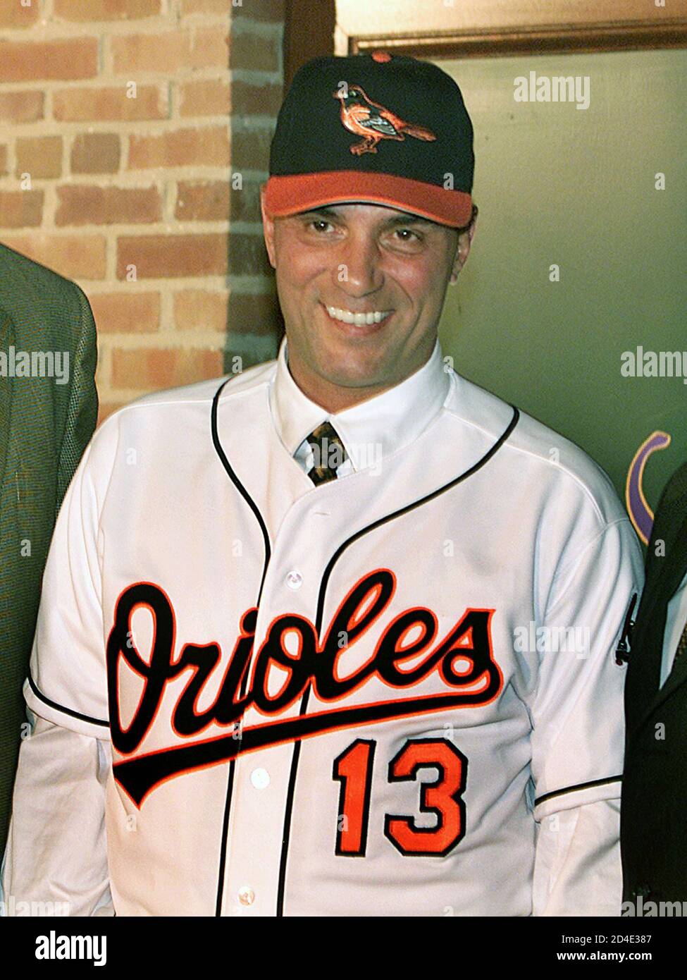 Lee Mazzilli smiles as he wears a Baltimore Orioles cap and uniform after a  press conference at Camden Yards in Baltimore, November 7, 2003. Mazzilli,  the former first base coach for the