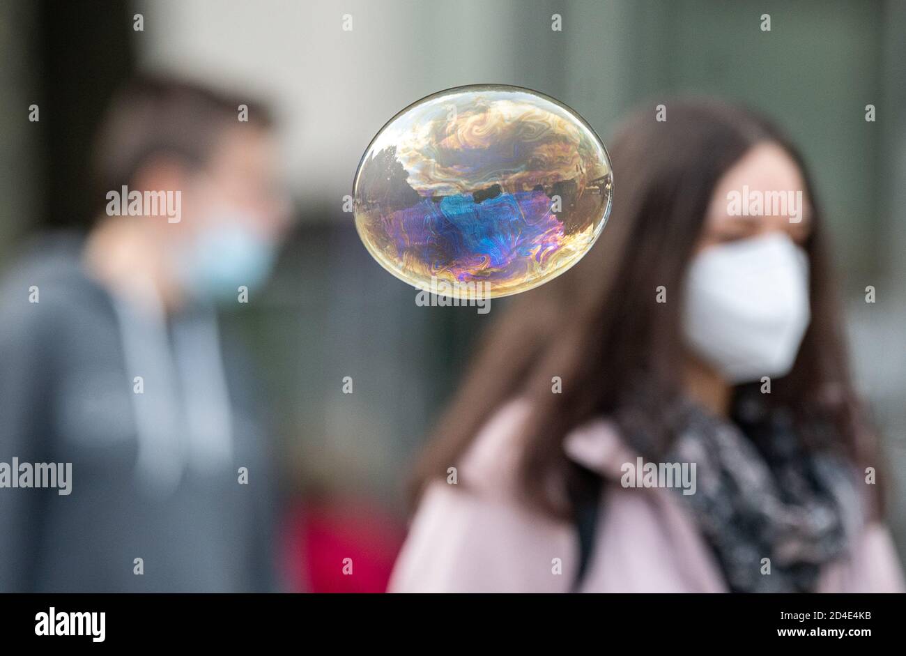 Stuttgart, Germany. 09th Oct, 2020. A soap bubble flies in front of people with mouth and nose protection. Chancellor Merkel is discussing the situation with the mayors of the eleven largest German cities in view of the sharp rise in corona figures. Credit: Sebastian Gollnow/dpa/Alamy Live News Stock Photo
