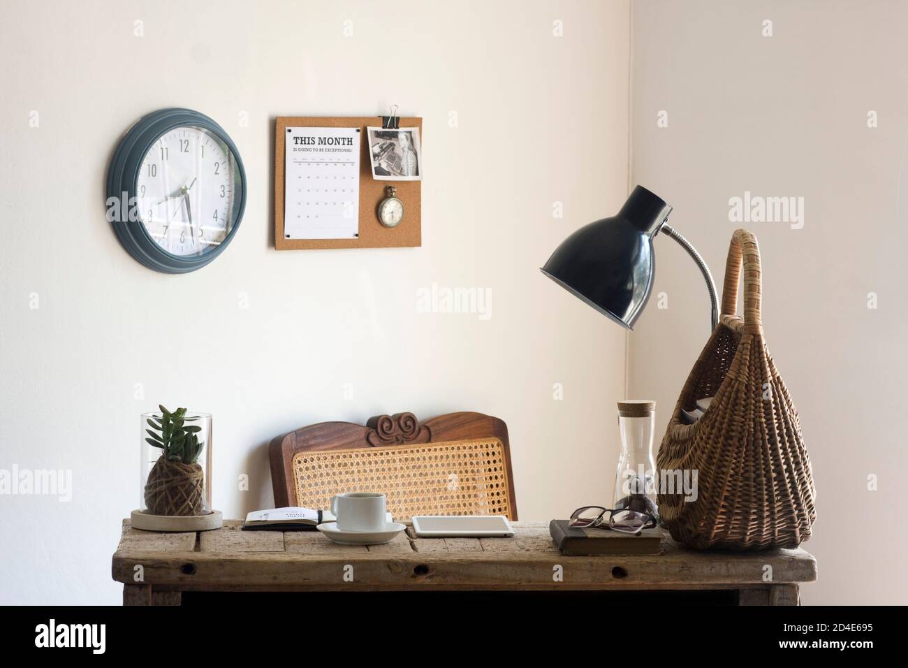 A tranquil home office space decorated with sustainable natural decor elements (like plants, rattan, cane, cork and jute) and a reclaimed wood desk Stock Photo