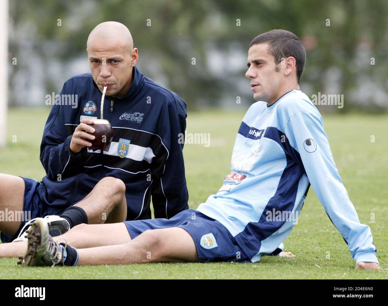 Uruguayan players Gustavo Varela (L) and Fabian Estoyanoff chat and drink  mate (herbal tea) prior to a team practice in Montevideo, Uruguay, November  15, 2004. Uruguay will face Paraguay on November 17,