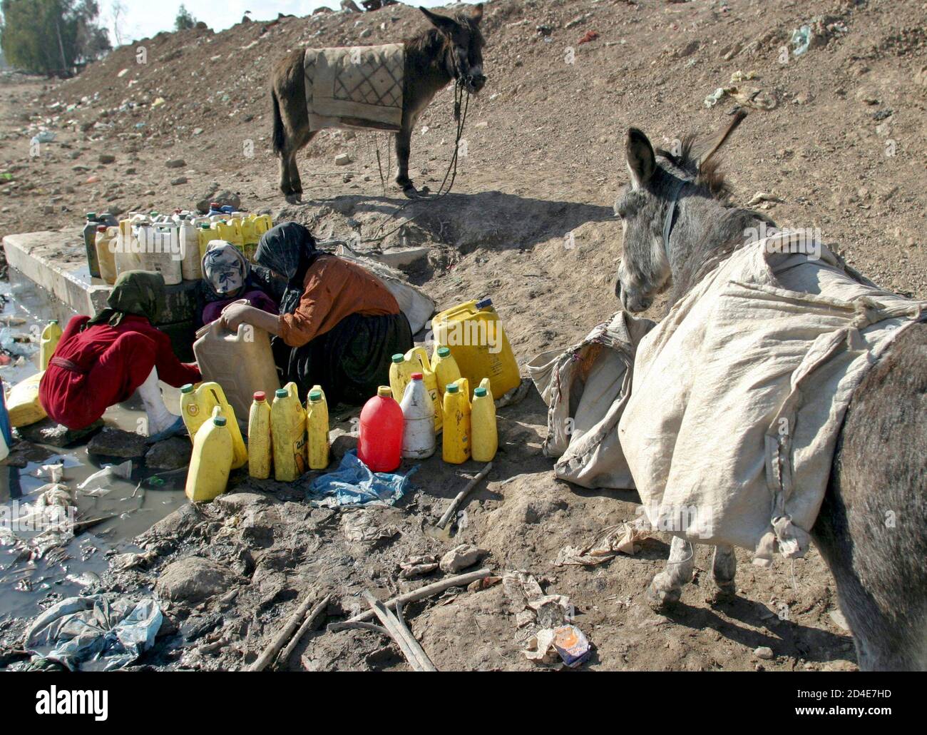 Iraqi girls collect water from a fetid drainage canal in eastern Baghdad,  February 2, 2005. While many Iraqis hope Sunday's national elections will  cement their post-war political power and improve their lives,