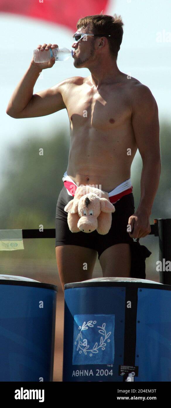 Germany's world champion rower Marcel Hacker drinks water as he wears a stuffed animal around his waist after a first place finish in the group B men's single sculls semi-finals at the Athens 2004 Olympic Summer Games August 19, 2004. Stock Photo