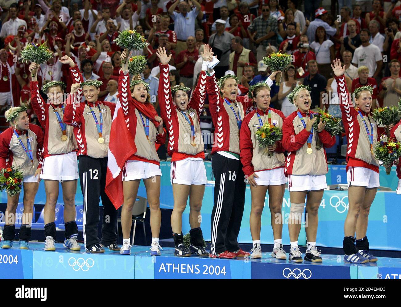 Danish women's Olympic handball champions raise their arms in unison during  the podium ceremony at the Athens 2004 Olympic Games, August 29, 2004.  Denmark defeated South Korea 38-36 on penalties to take