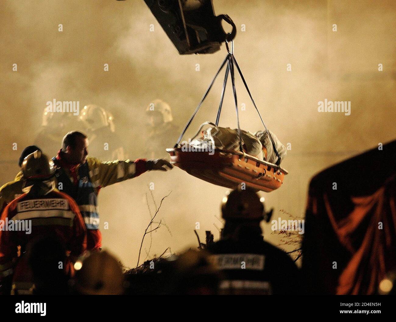 The body of a firefighter is lifted from an underground car park, the roof of which collapsed and buried up to seven firefighters underneath it in the town of Gretzenbach between the cities of Basel and Zurich November 27, 2004. Seven Swiss fire-fighters were presumed dead on Saturday after they were trapped under the collapsed roof of a burning underground car park."Of the seven persons, five have been located and show no signs of life, so we expect that they are dead," chief fire inspector Paul Haus said. All seven were thought to have suffocated. REUTERS/Ruben Sprich RS/ABP Stock Photo