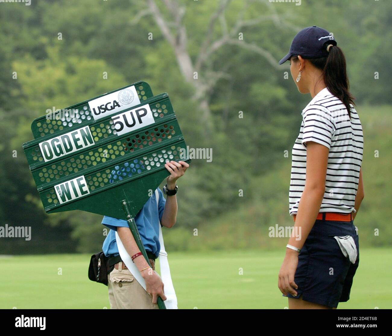 Michelle Wie looks at the standard with Clay Ogden's score defeating her on 14th green in their quarter-final round in Lebanon, Ohio.  Michelle Wie (R) of the U.S. looks at the standard with Clay Ogden's score defeating her 5 and 4 on the 14th green in their quarter-final round of match play in the 2005 United States Amateur Public Links Championship at Shaker Run Golf Club in Lebanon, Ohio, July 15, 2005. REUTERS/John Sommers II Stock Photo