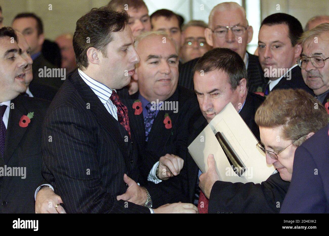 PRO AND ANTI GOOD FRIDAY AGREEMENT ASSEMBLY MEMBERS SCUFFLE FOLLOWING DAVID TRIMBLE'S RE-ELECTION AS FIRST MINISTER AT STORMONT.   Democratic Unionist Party (DUP) member Ian Paisley Jr (Lnd 2) tussles with Sinn Fein chairman Mitchell McLaughlin (2nd R, holding papers) and Alistair McDonald (bottom right) of Social Democratic and Labour Party (SDLP) during a heated argument as DUP leader Ian Paisley (rear 3rd R) looks on at Stormont November 6, 2001. Scuffles broke out between pro and anti Good Friday Agreement Assemblymen as newly re-elected First Minister David Trimble gave an acceptance spee Stock Photo