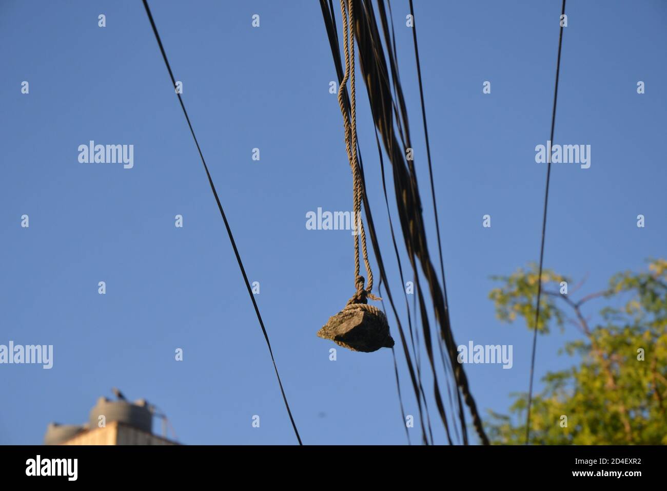 hanging stone on the electric wire for balancing of the wires. Picture taken in Kathmandu, Nepal Stock Photo