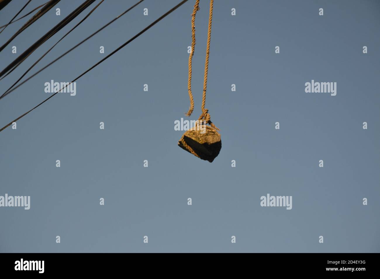 hanging stone on the electric wire for balancing of the wires. Picture taken in Kathmandu, Nepal Stock Photo