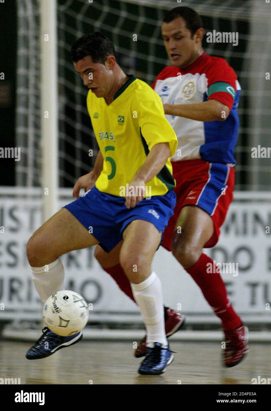 Vinicius Texeira (L) from Brazil fights for the ball with Gustavo Franco from Paraguay during a five-man indoor soccer match at the VII South American Games in Rio de Janeiro, August 7, 2002. REUTERS/Sergio Moraes  SM/SV Stock Photo