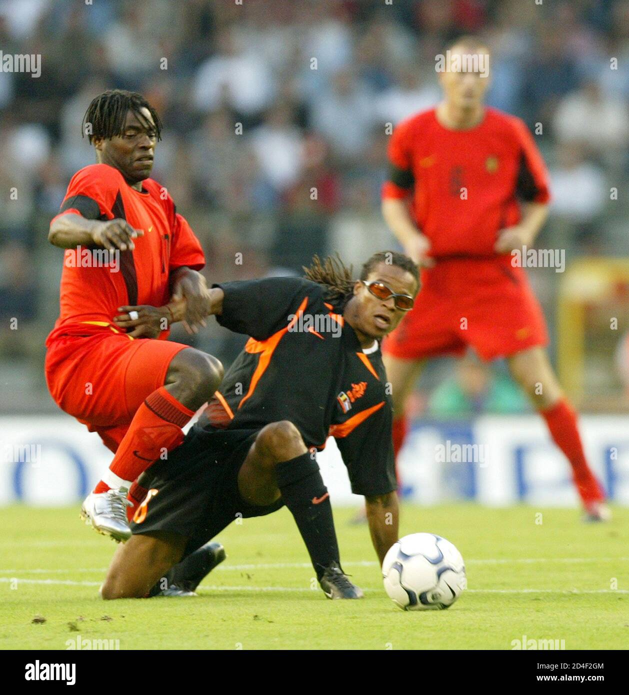 Belgium's Mbo Mpenza (L) duels for the ball with Netherlands' Edgar Davids  (C) while Belgium's Philippe Clement (R) watches during their international  friendly match at the King Baudouin stadium in Brussels August