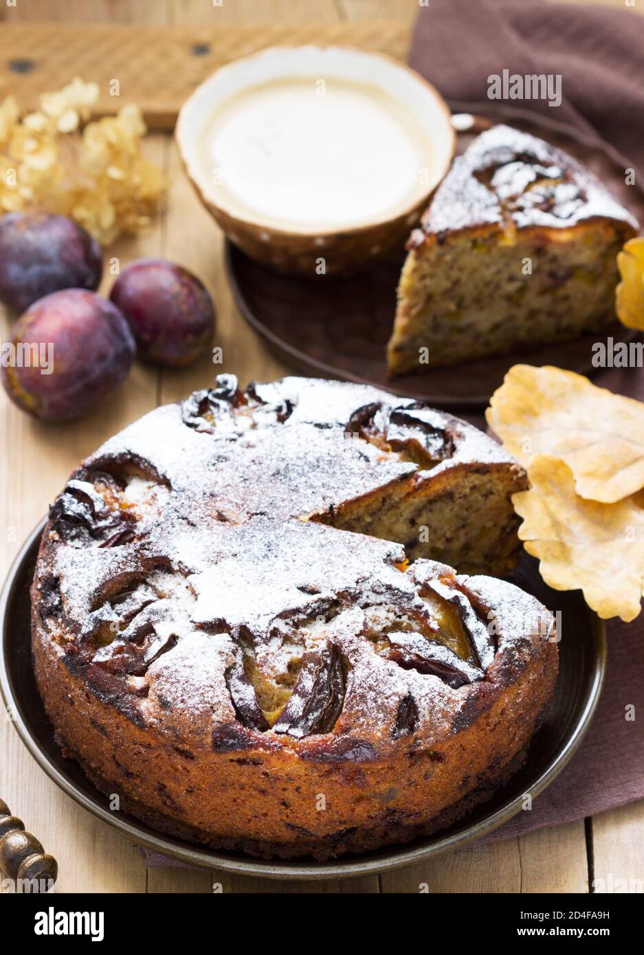 Plum pie with nuts and chocolate on a wooden background. Rustic style. Stock Photo