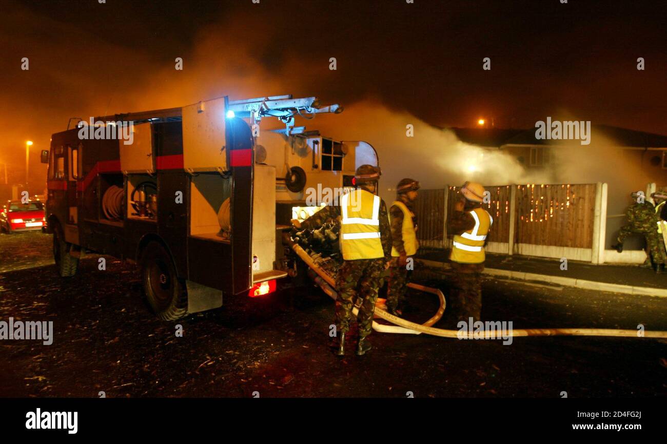 Army personnel extinguish a car fire with military Green Goddess fire trucks in Manchester, during a nationwide strike by firefighters, November 14, 2002. Firefighters are going ahead with a 48-hour national strike starting November 13 after their union rejected the 11 per cent pay offer. Stock Photo