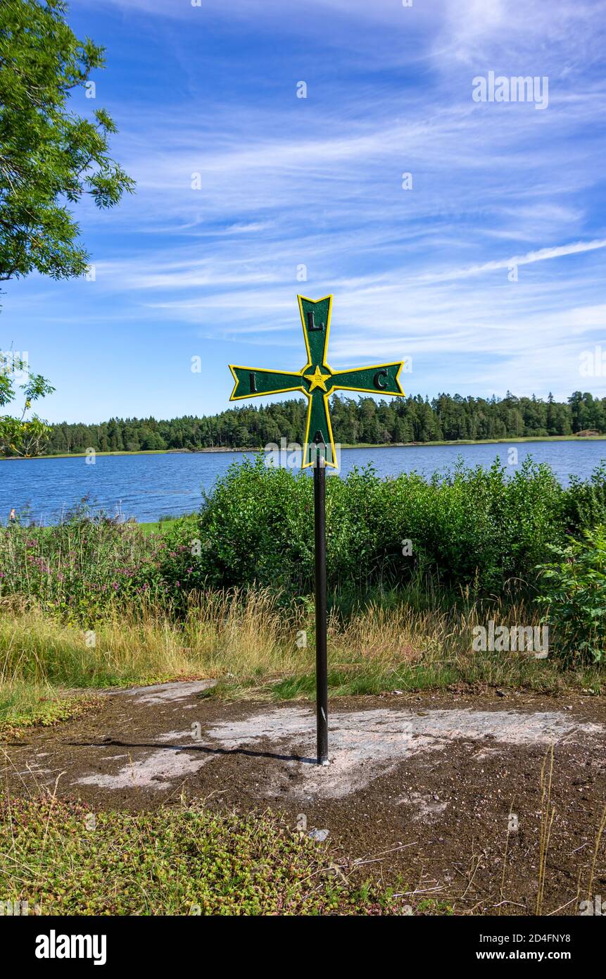 Old historical iron cross pattée with masonic symbolism in a grove in front of Läckö Castle on Lake Vänern, Västergötland, Sweden. Stock Photo