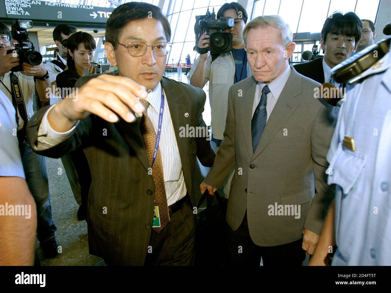 Former U.S. Army deserter Charles Jenkins (RC) looks on after arriving at Washington Dulles International Airport in Dulles, Virginia June 14, 2005. Jenkins, 65, deserted to North Korea from South Korea during the Cold War and now lives in Japan with his wife. This is Jenkins' first trip to the U.S. in 40 years which he reportedly intends to spend visiting his elderly mother in North Carolina. REUTERS/Shaun Heasley SH/KI Stock Photo