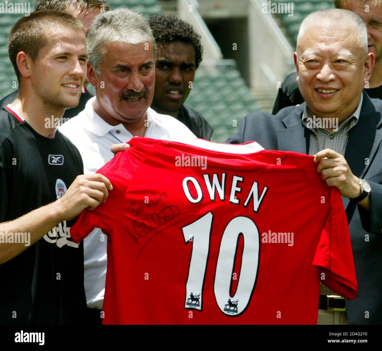 Liverpool player Michael Owen (L) of England presents his jersey to Hong  Kong Chief Executive Tung Chee-hwa (R) after a training session at Hong  Kong Stadium July 26, 2003. Liverpool will play