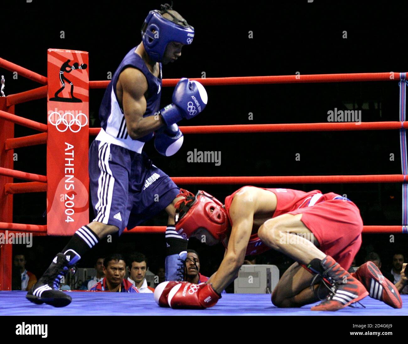 Cuba's Yuriorkis Gamboa Toledano (L) stands over  Somjit Jongjohor (R) of Thailand in their men's flyweight (51kg) round of 16 boxing bout at the Athens 2004 Olympic Summer Games August 21, 2004. Gamboa Toledano won the bout. Stock Photo