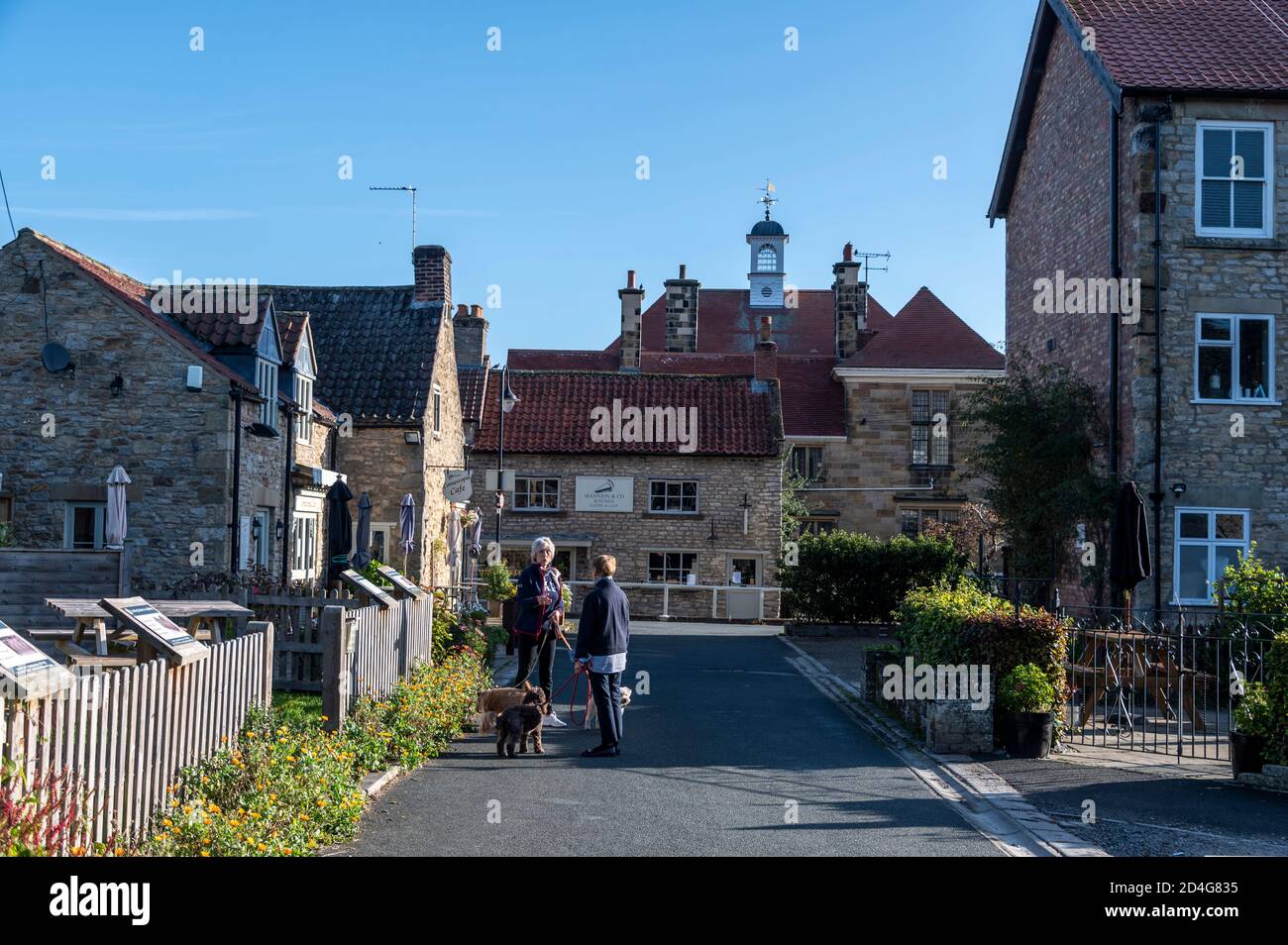 A neighbourly chat near the medieval ruin Keep at Helmsley Castle in the small market town of Helmsley set on the southern boundary of the North York Stock Photo