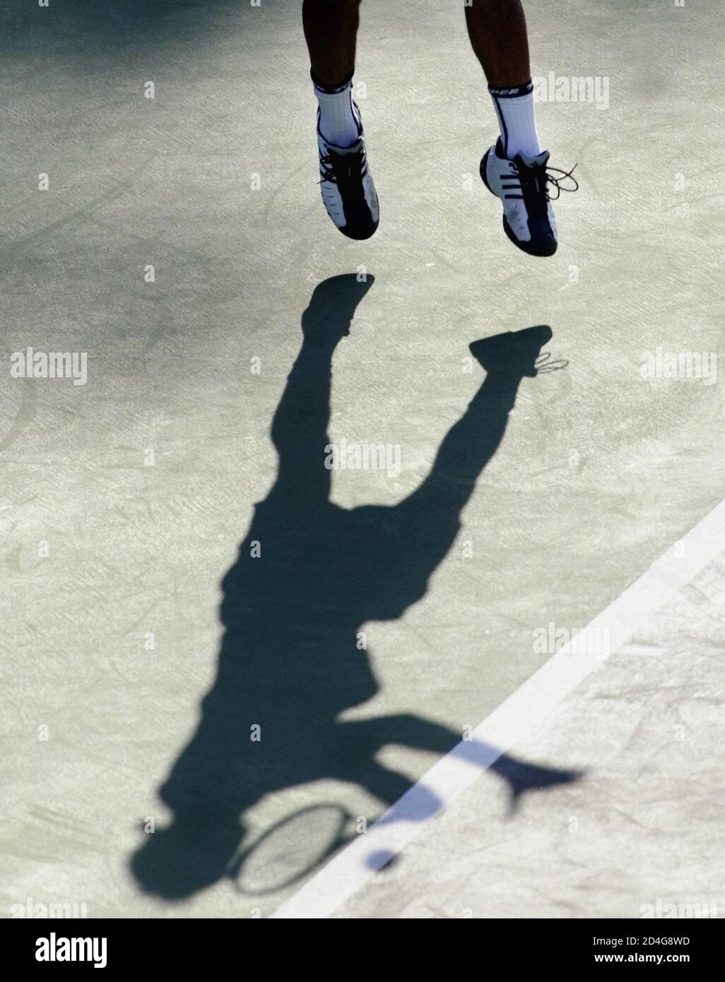 The shadow of Jose Antonio De Armas of Venezuela is cast onto the court as he hits a return to Ivan Miranda of Peru during their Davis Cup singles match in Caracas, March 6, 2005. REUTERS/Howard Yanes  JS Stock Photo