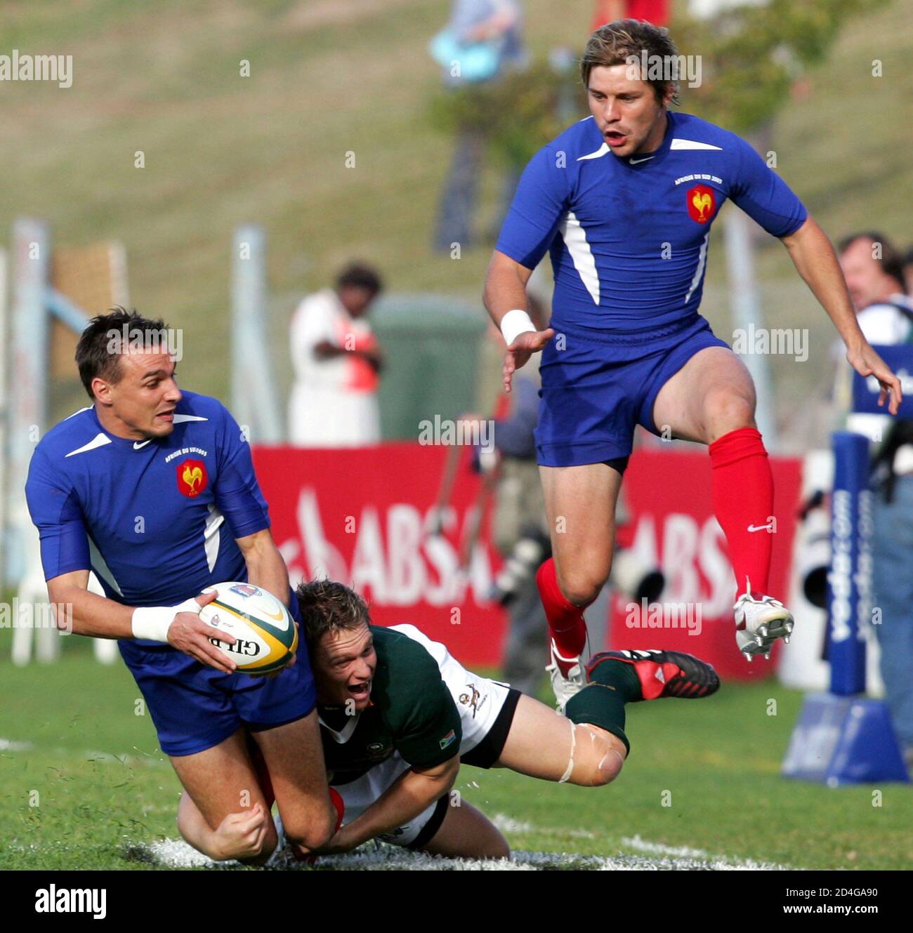 France fullback Nicholas Brusque (L) is tackled by South Africa's Jean de Villiers watched by Vincent Clerc (R) during the second test match in Port Elizabeth, June 25, 2005. [The Springboks beat France 27-13 in the second test on Saturday to clinch the series 1-0 in Port Elizabeth.] Stock Photo