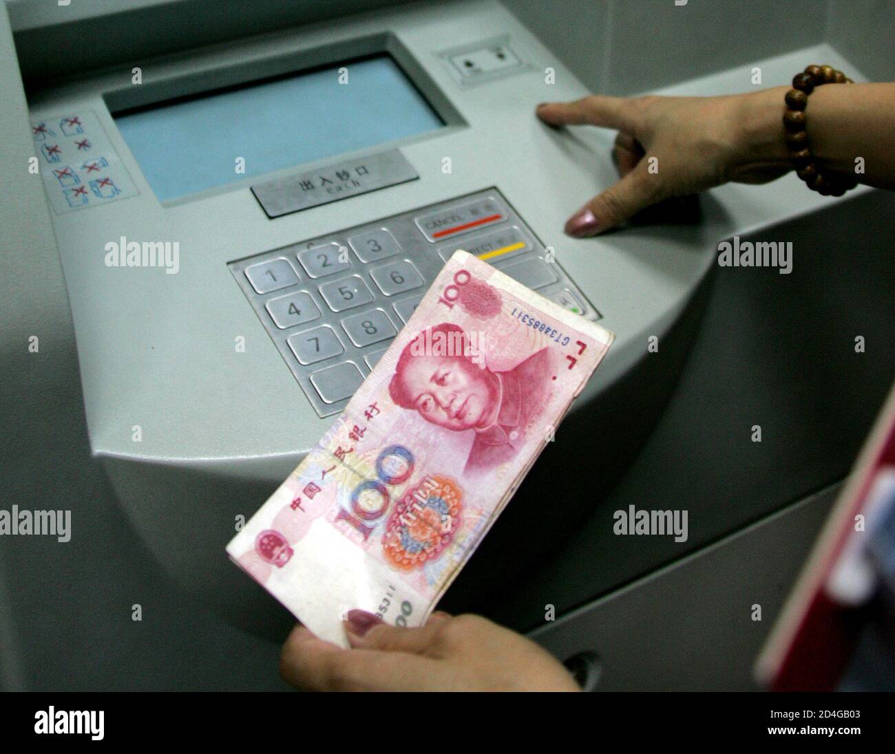 A Chinese woman deposits her Chinese money at an ATM in Beijing July 21