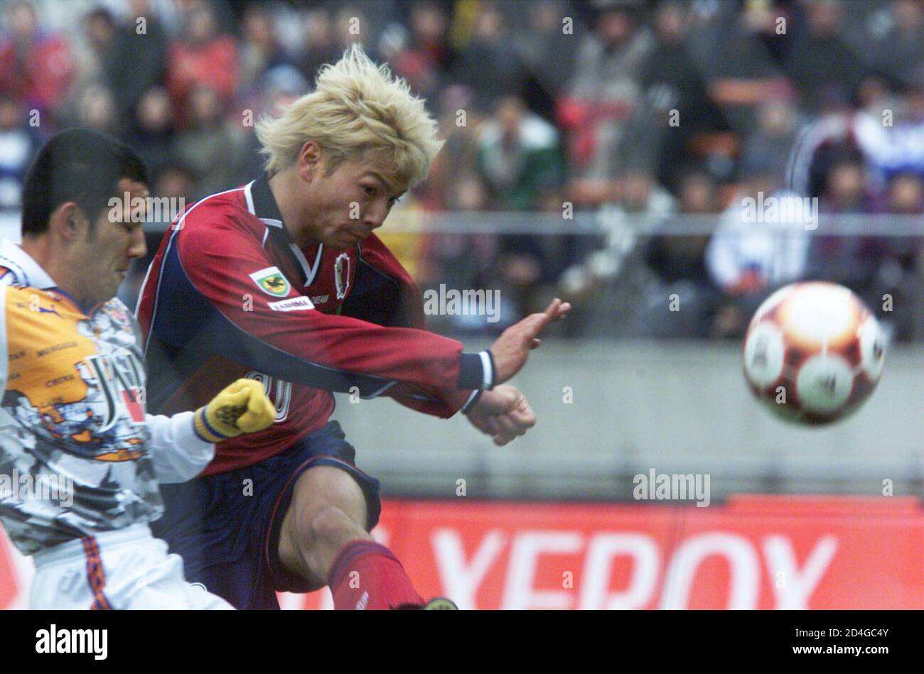 Kashima Antlers striker Takayuki Suzuki (R) kicks the ball while Shimizu  S-Pulse midfielder Teruyoshi Ito attempts to block during the Xerox Cup at  the National Stadium in Tokyo March 3, 2001. Shimizu