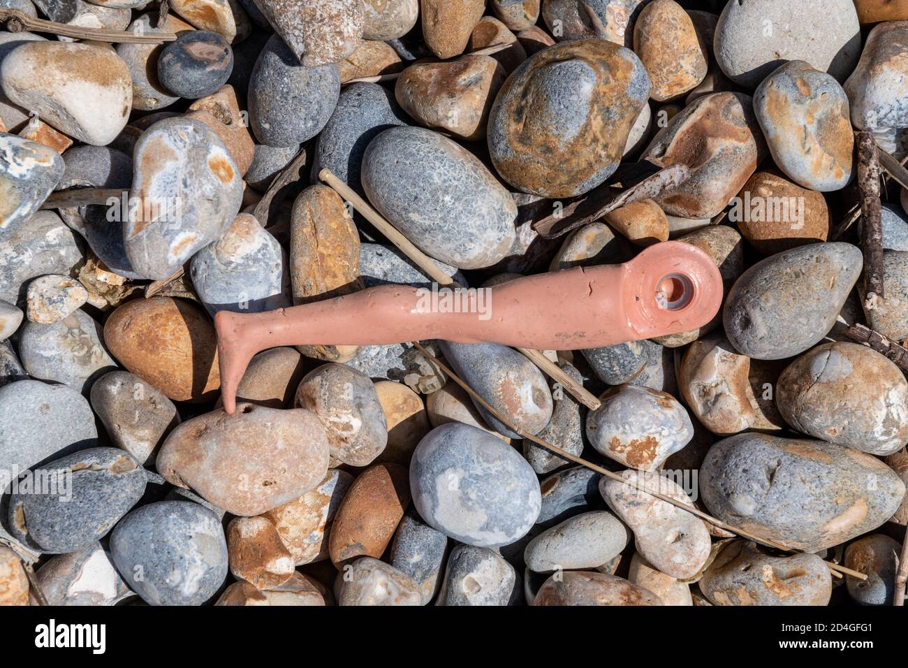 plastic waste on a pebble beach Stock Photo