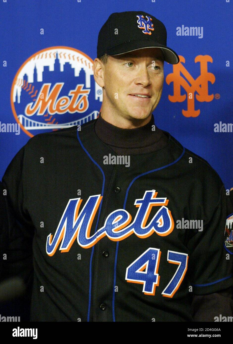 Newly acquired left handed starting pitcher for the New York Mets Tom  Glavine smiles as he wears his Mets hat and jersey for the first time at a  news conference to fomally