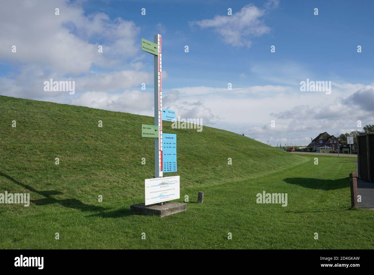 Marker board showing extent of historic high tides with sea defence embankment behind. Wadden Sea, East Frisia. Germany Stock Photo