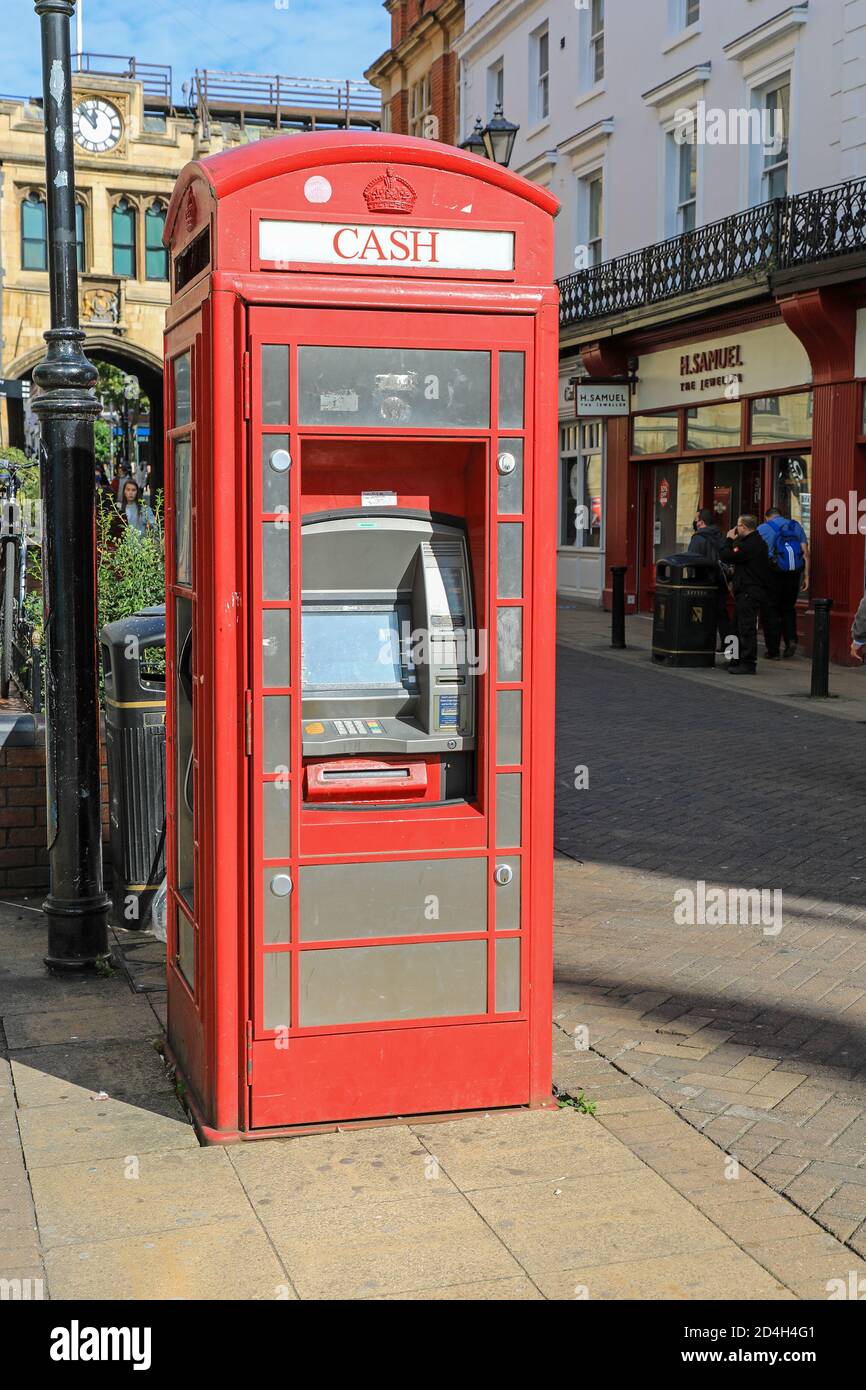 An old red telephone box or telephone kiosk converted to a cash machine in the High Street, City of Lincoln, Lincolnshire, England, UK Stock Photo