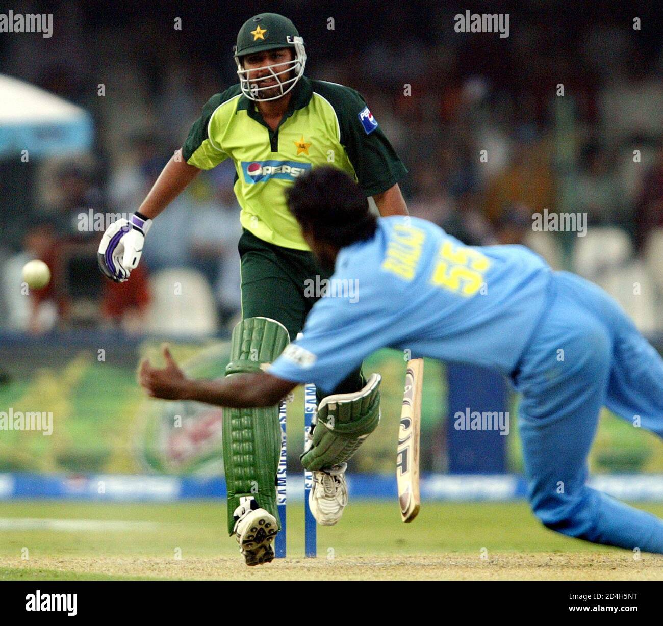 India's Lakshmipati Balaji dives trying to stop a shot from Pakistan's  Inzamam-ul Haq (behind) in