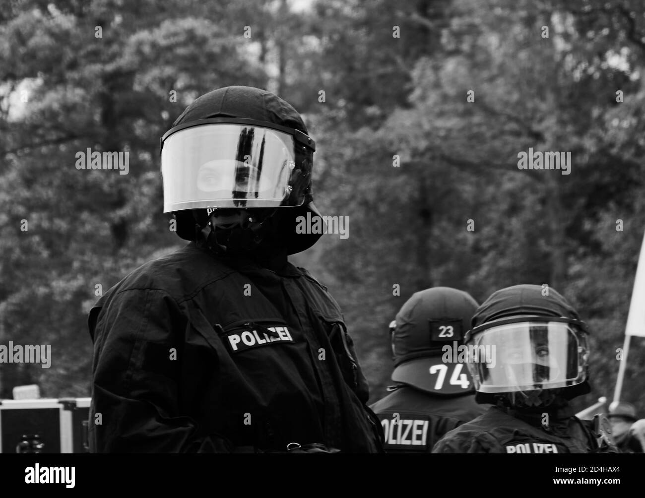 Eschede, Germany, September 26., 2020: Young German policemen look through their helmet visors in black uniforms, black and white Stock Photo