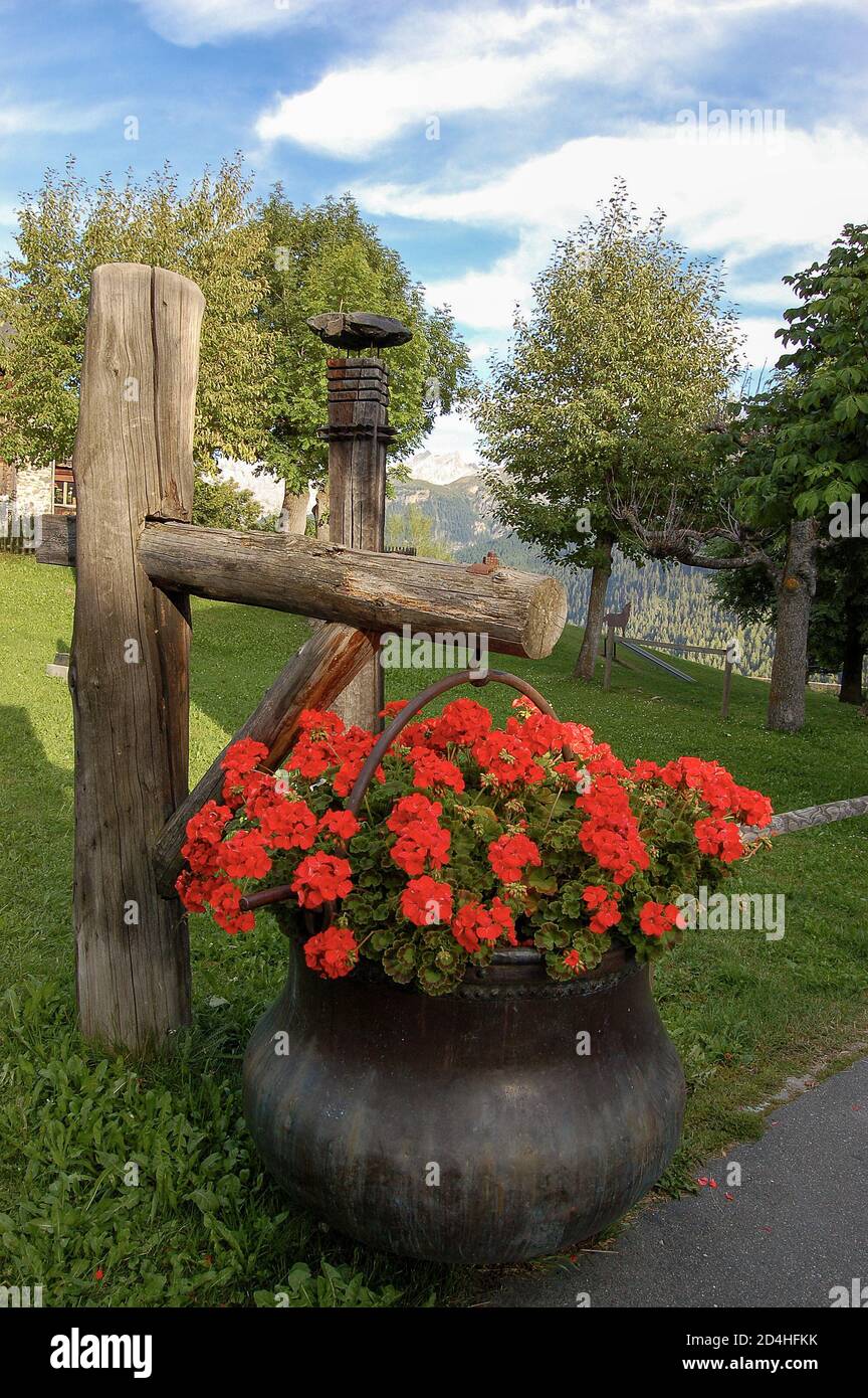 Red geraniums in a copper cauldron in the ancient village of Guarda, Scuol  municipality, Engadin valley, Graubunden canton, Switzerland, Europe Stock  Photo - Alamy