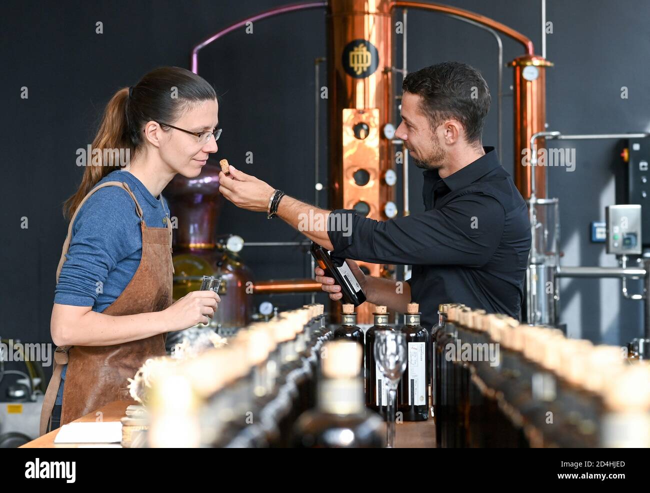 08 October 2020, Berlin: Employee Dorina Lücke and Tim Müller, owner of DSM Deutsche Spirituosen Manufaktur GmbH, test the 'Herbstlaub' variety in the manufactory's showroom. It is distilled without dry, brown leaves and the tree species is a company secret. Since 2017, the premium distillery has been producing 110 different types of brandies, spirits, liqueurs, gin and vodka, some of them with completely new recipes 'Made in Berlin'. The distillery consistently refrains from adding flavours and colourings and produces in small batches. The selected ingredients are organic quality wherever pos Stock Photo