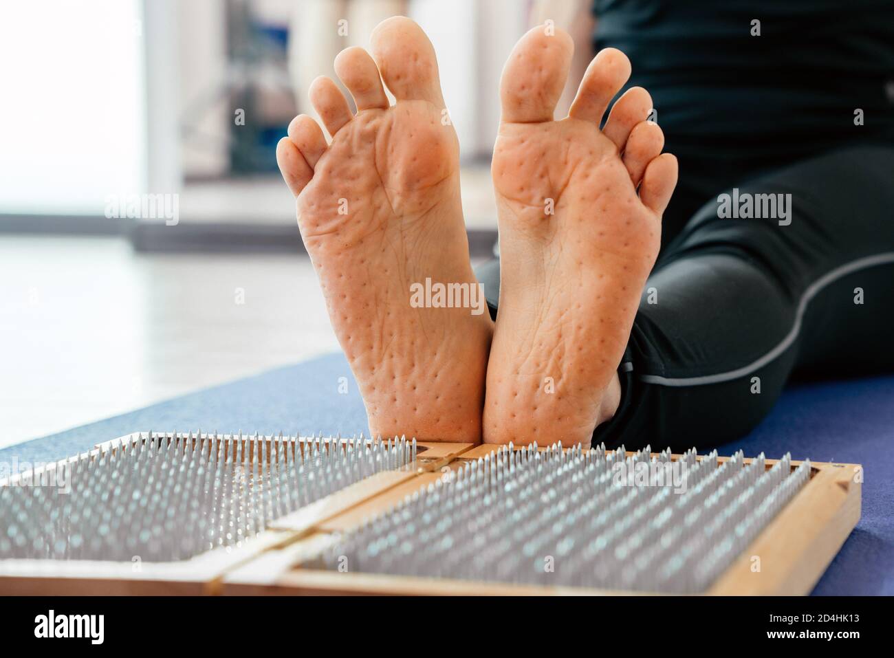 Feet and wooden board with sharp metal nails. Sadhu foot board. Yoga