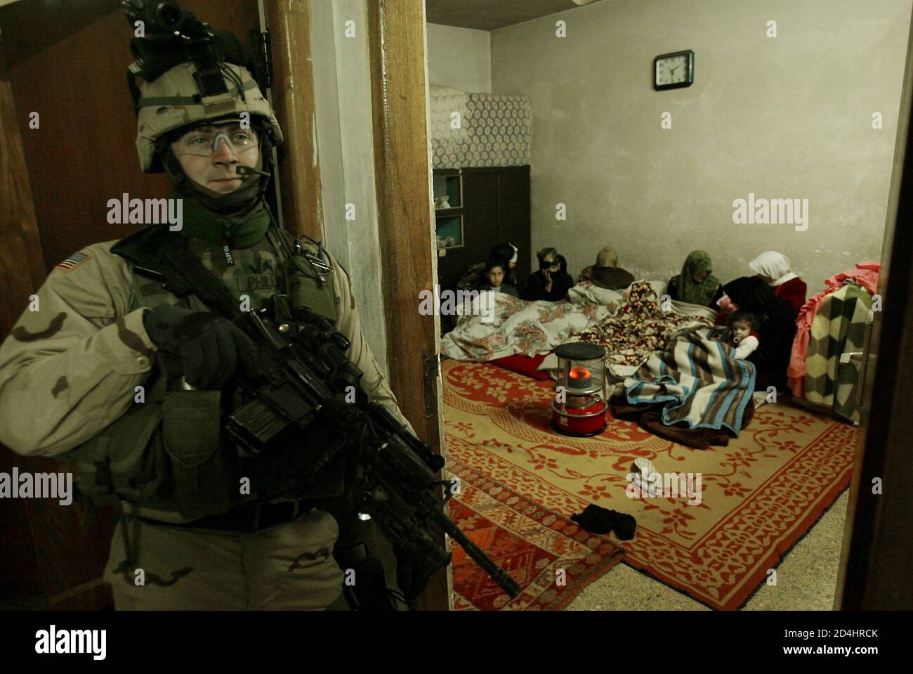 U.S. soldiers from Charlie company of the 3rd Battalion, 21st Infantry searches a house looking for explosives during a raid in Mosul, northern Iraq early January 15, 2005. [A U.S. commander warned al Qaeda ally Abu Musab al-Zarqawi, a driving force behind escalating attacks in the build up to Iraq's election, that American troops were on his trail and would capture or kill him sooner or later.] Stock Photo