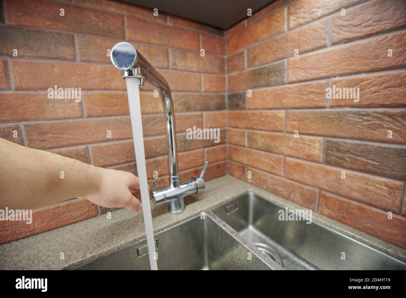 Water running from metal faucet in kitchen. Closing tap Stock Photo Alamy