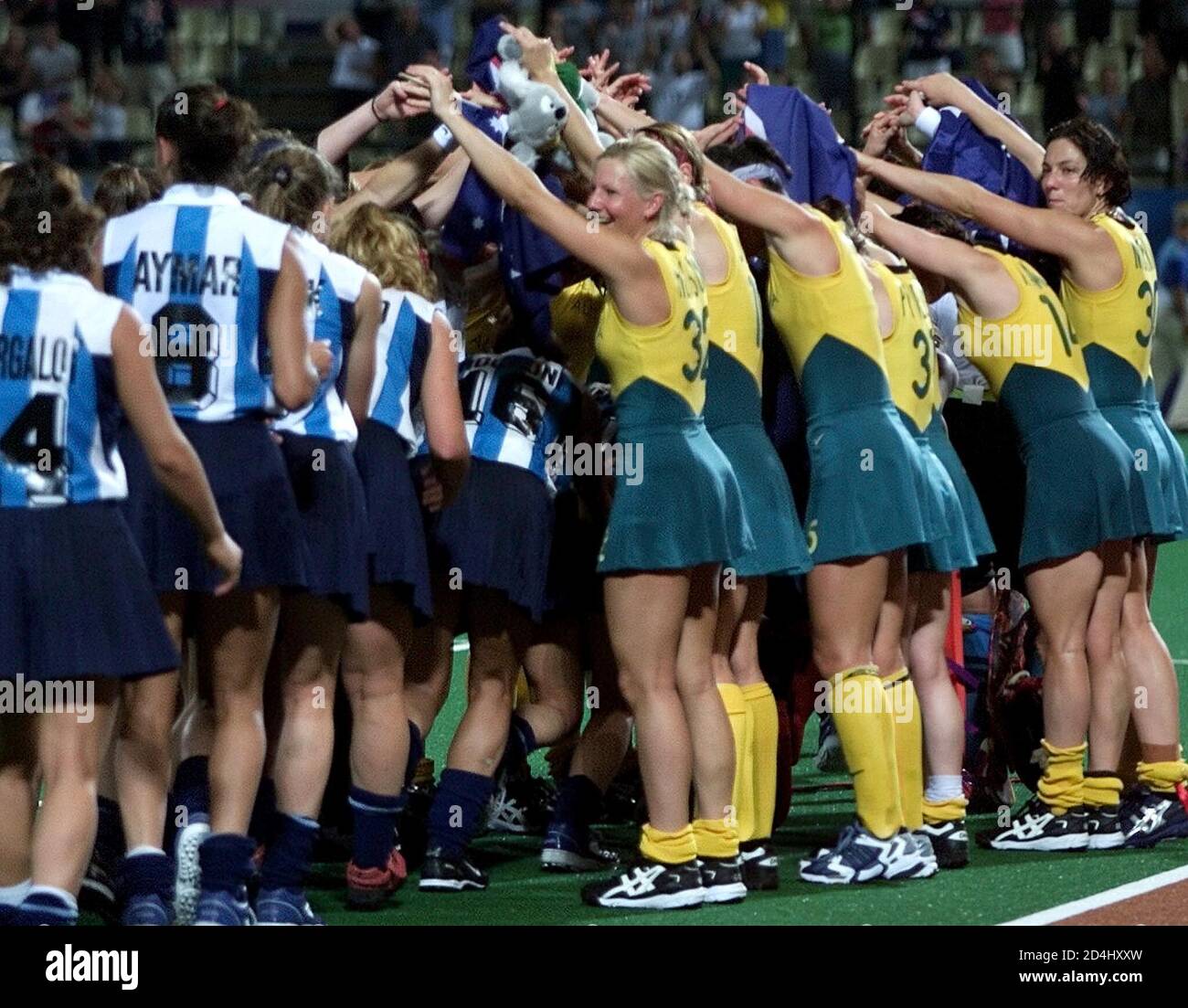 Members of the Australian field hockey team (R) make a tunnel for their