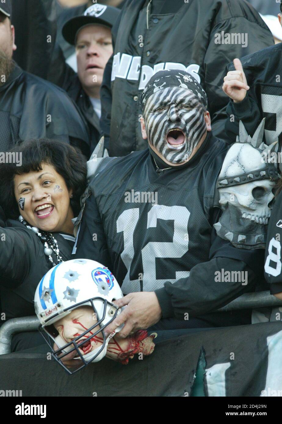A costumed Oakland Raiders fan holds a beheaded mannequin of a