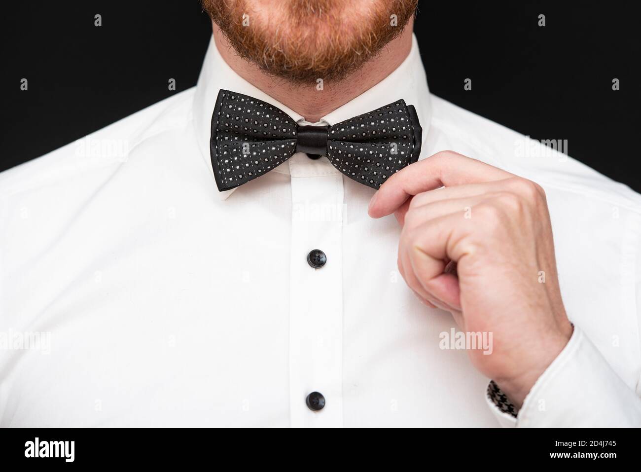 Redhead man with red beard dressed in black bowtie and white shirt Stock Photo