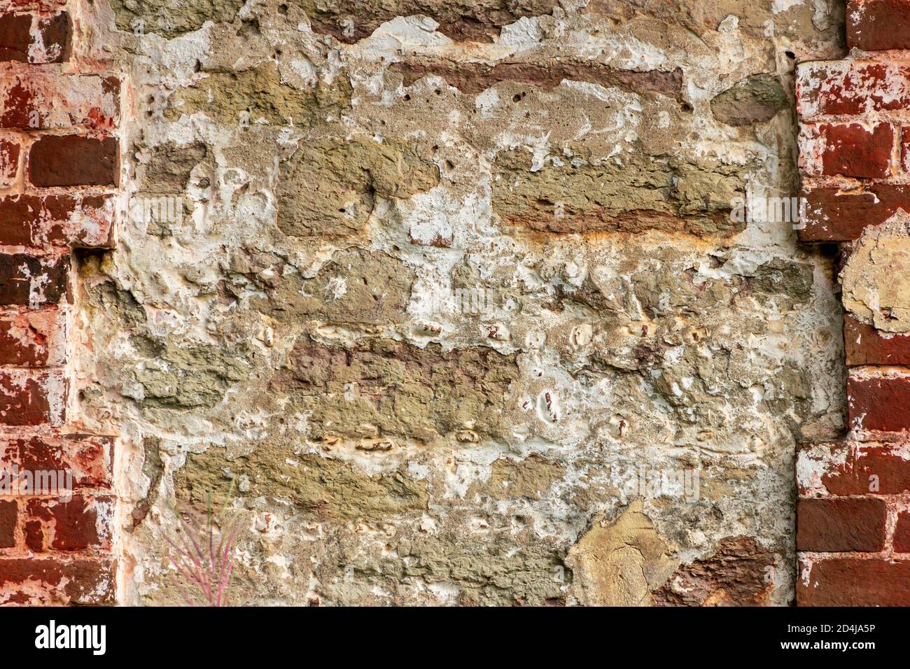 The surface of an old stone wall, masonry of uneven wild hewn stones. Stock Photo