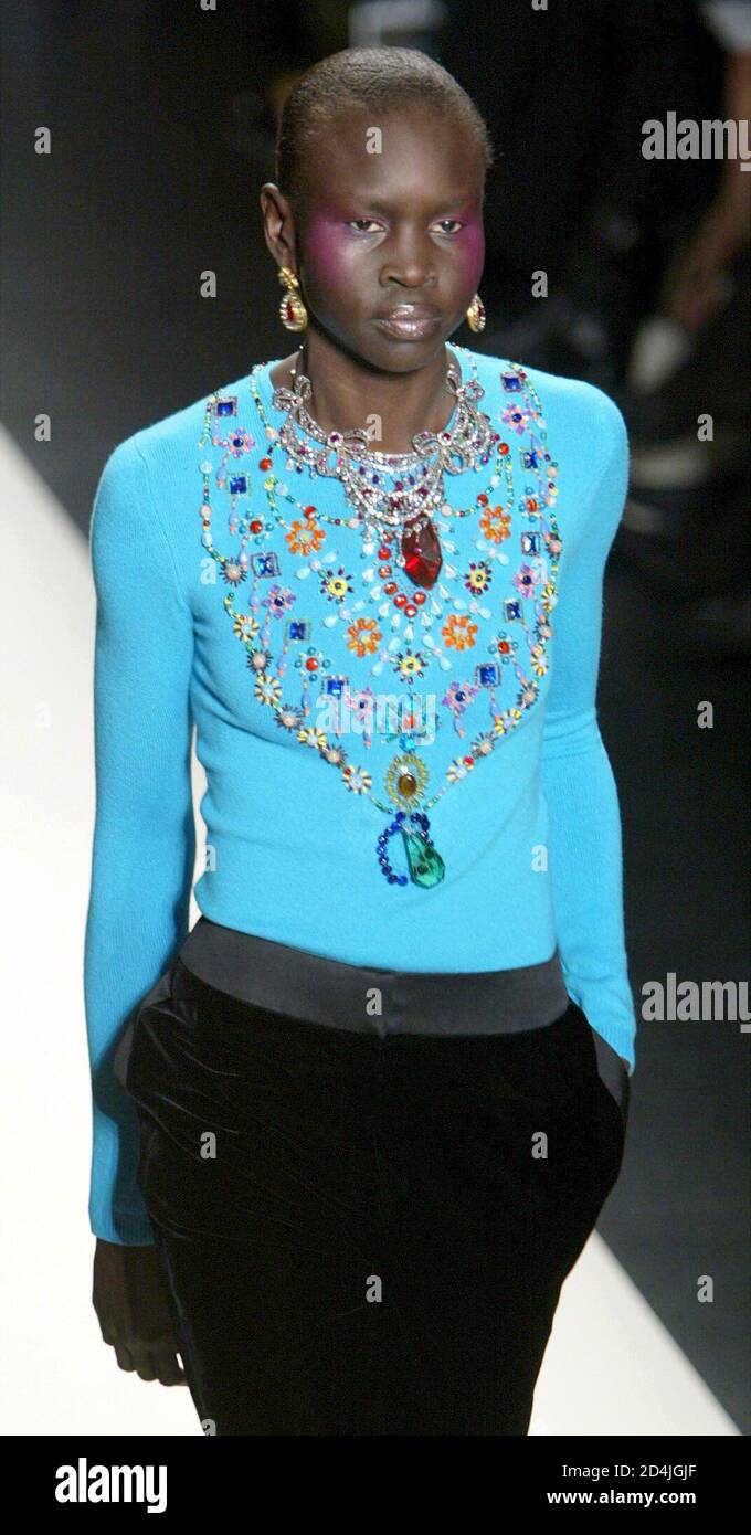 Alek Wek wears a turquoise embroidered cashmere sweater with a black velvet  tuxedo pant at designer Oscar de la Renta's Fall 2003 fashion show in New  York on February 10, 2003 Stock Photo - Alamy