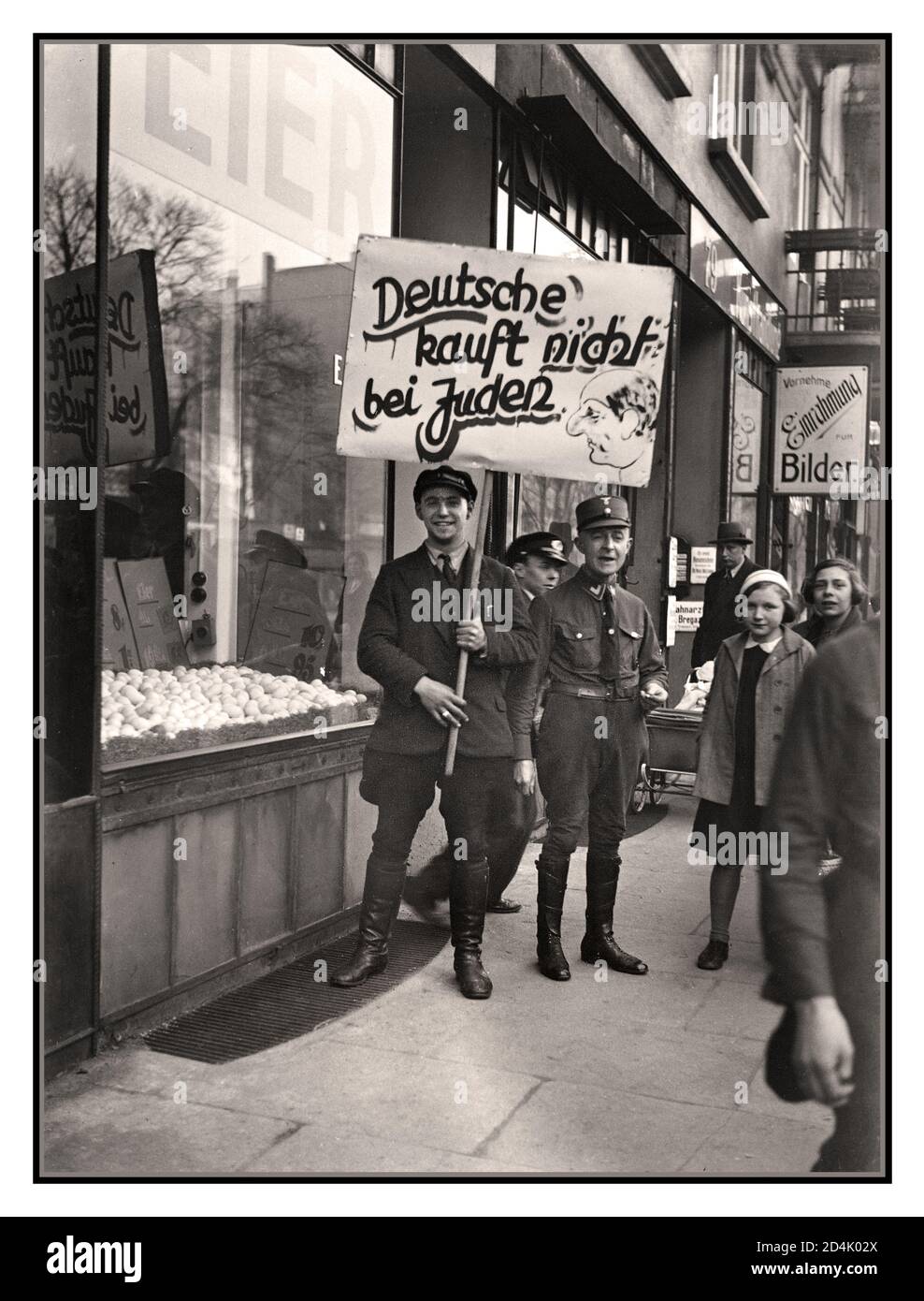 1930's Germany Nazi Anti Jewish anti-Semitic boycott propaganda April 1st 1933 Vintage Pre-War anti-semitic crude racist inflammatory placard with smiling NSDAP ‘goons’.... 'Germans do not buy from Jews' outside a Jewish owned business.. Nazi government organized a one-day boycott of all Jewish-owned businesses in Germany, with the assistance of Julius Streicher, publisher of the anti-Semitic daily newspaper Der Sturmer. The boycott failed to attract public support. Days later, laws were proclaimed to remove German Jews from various occupations. Stock Photo