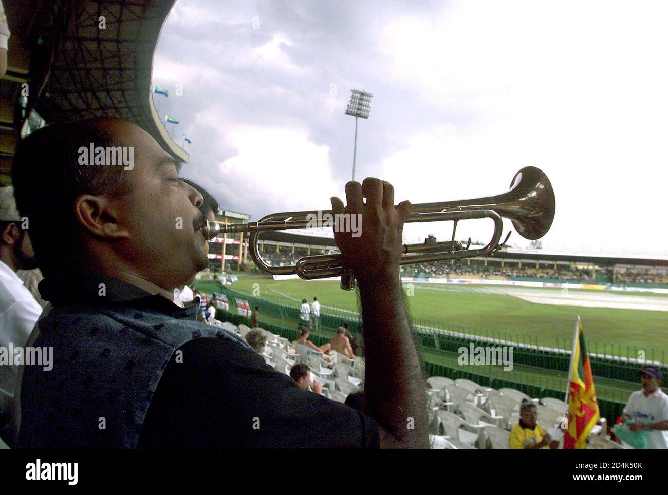 Sri Lankan cricket fans play music at R. Premadasa stadium as plastic sheets cover the pitch to protect it from rain prior to the start of the second one-day international between England and Sri Lanka in Colombo November 21, 2003. Start of play was delayed due to wet ground conditions and a light drizzle. Sri Lanka leads 1-0 in the three one-day internationals series between the two countries. REUTERS/Anuruddha Lokuhapuarachchi  AL/TW Stock Photo