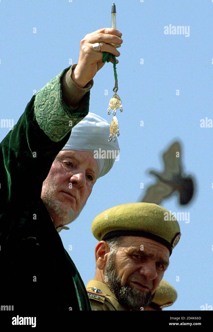 Kashmiri Muslim priest Ghulam Hassan Banday displays a relic (in glass) of  Prophet Mohammed on the occasion of Eid-e-Milad from the minaret of  Hazratbal shrine in Srinagar May 3, 2004. [Thousands of