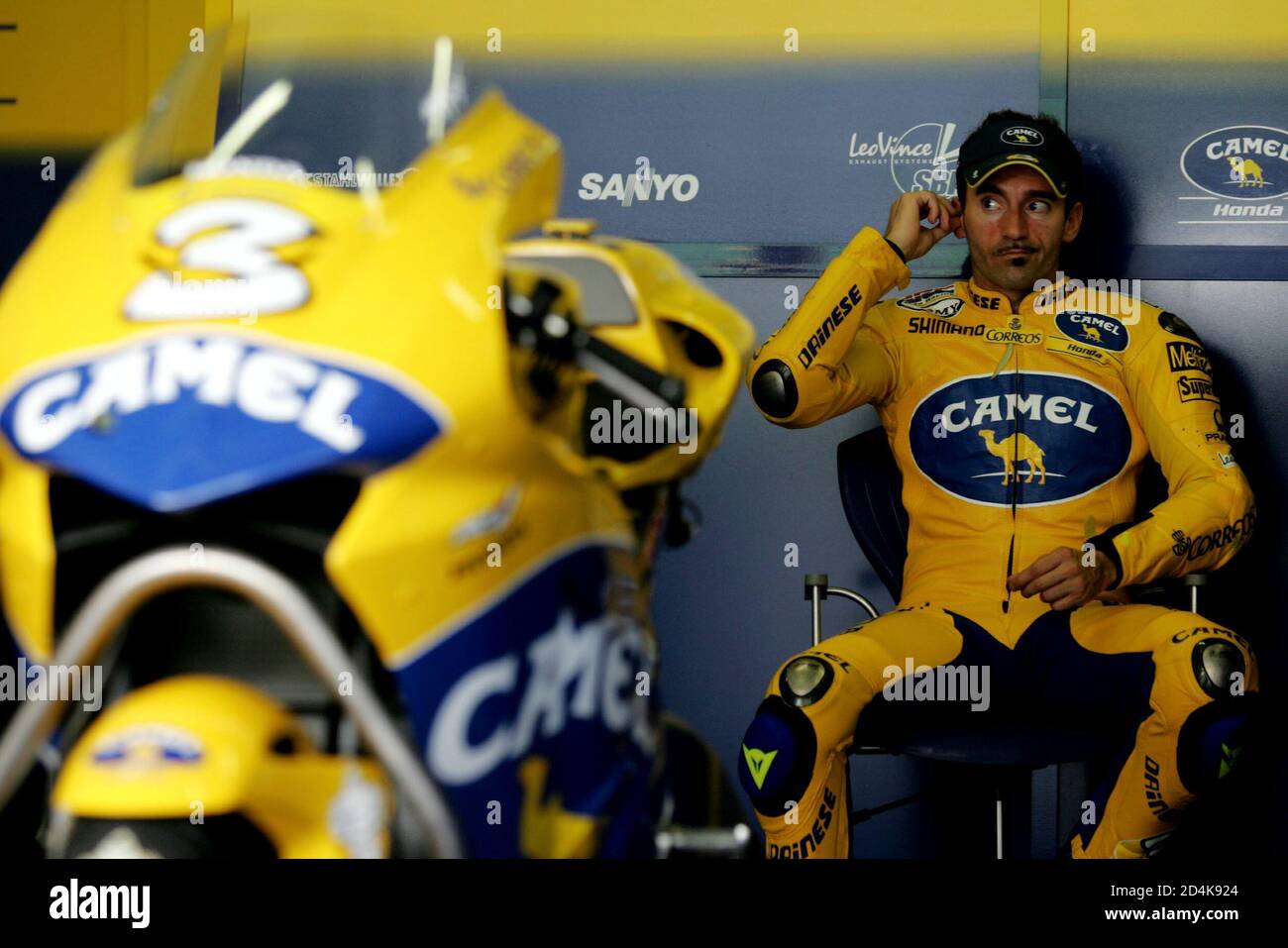 Italian MotoGP rider Max Biaggi of team Honda puts on his ear plug before the start of a qualifying practice session at Malaysia's Sepang International Circuit on October 8, 2004. Malaysian Motorcycle Grandprix 2004 will be held on Sunday. Stock Photo