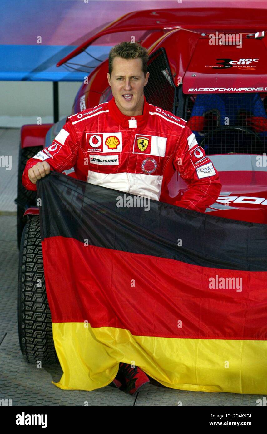 Germany's World Champion Formula One driver Michael Schumacher poses with the German flag in Paris, December 4, 2004. Schumacher is taking part in the Race of Champions exhibition event at the Stade de France stadium, converted into a race track for this special event. [Sixteen top rally and Formula One drivers will compete in the charity event to which the proceeds will go to research for bone marrow and brain disease.] Stock Photo