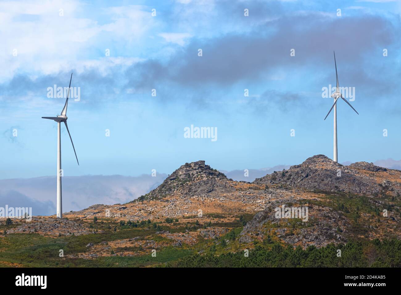 View of a wind turbines on top of mountains, cloudy sky as background ...