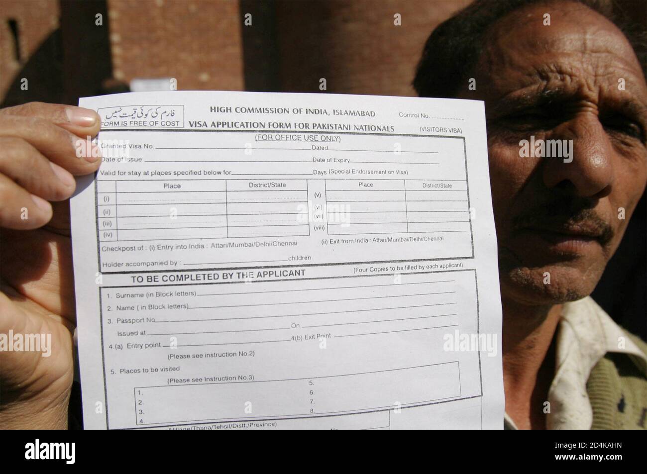 A Pakistani cricket fan holds his Indian visa form outside the Gaddafi  Stadium in Lahore February 25, 2005. India has opened special visa offices  in Pakistani cities to process the applications of